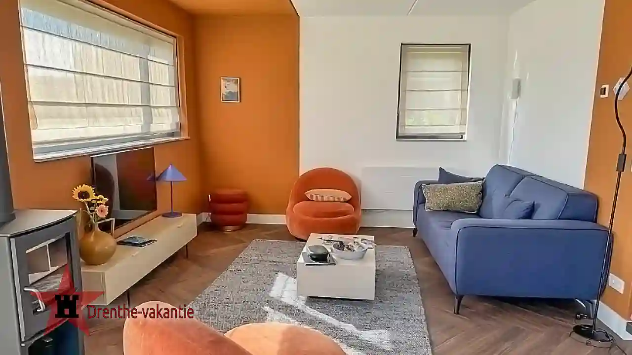 De woonkamer van het 4 persoons huisje met houtkachel en smart tv.